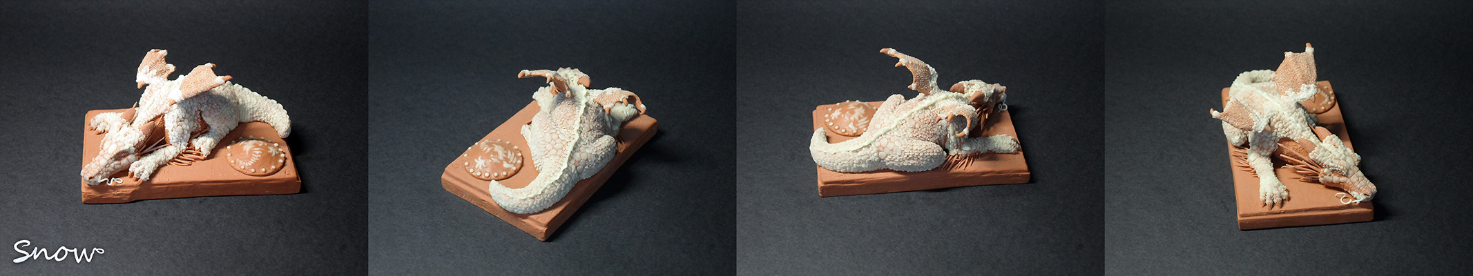 "Snow" - A resting dragon next to a knight's shield. The figurine is made from self adhesive Plasticine, and its size is 10.2cm X 6.3cm X 5.1cm