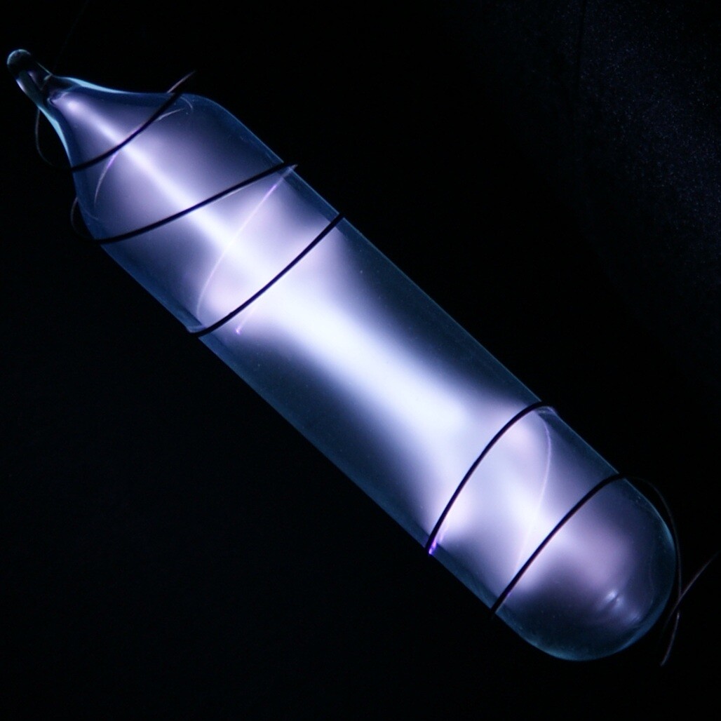 Inspired in part by ampoules containing gases like this one — deuterium, an isotope of hydrogen — and Geissler tubes.

CC via Wikipedia, by https://images-of-elements.com/deuterium.php