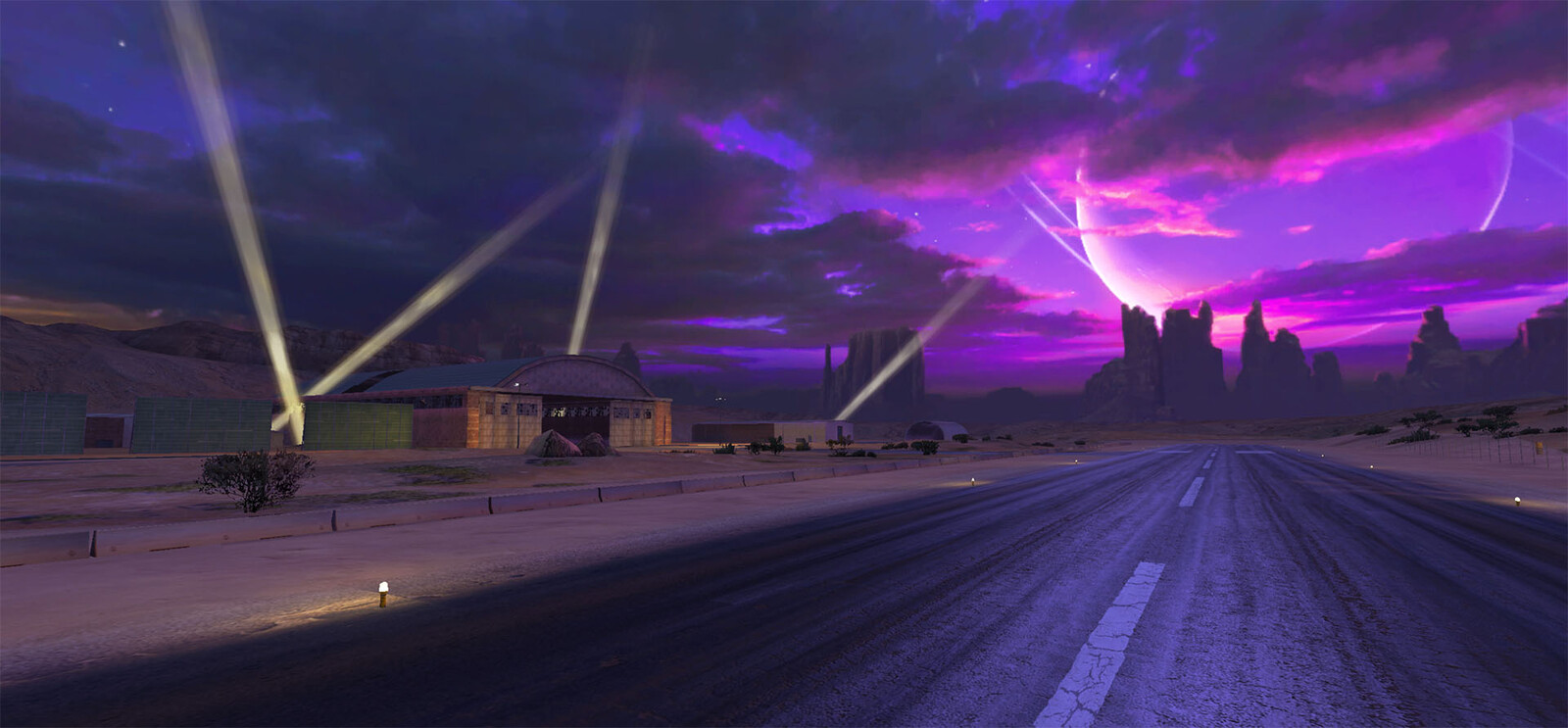 The end of the track which terminates in a runway showing a hangar and searchlights.